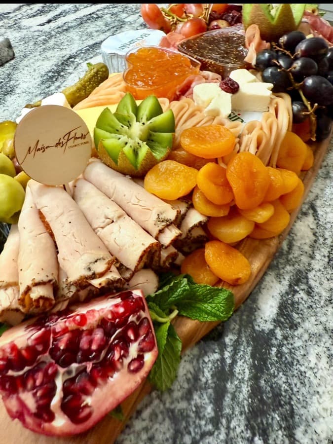 Maison's full branded charcuterie board with meats, cheeses, seasonal fruit, and preserves