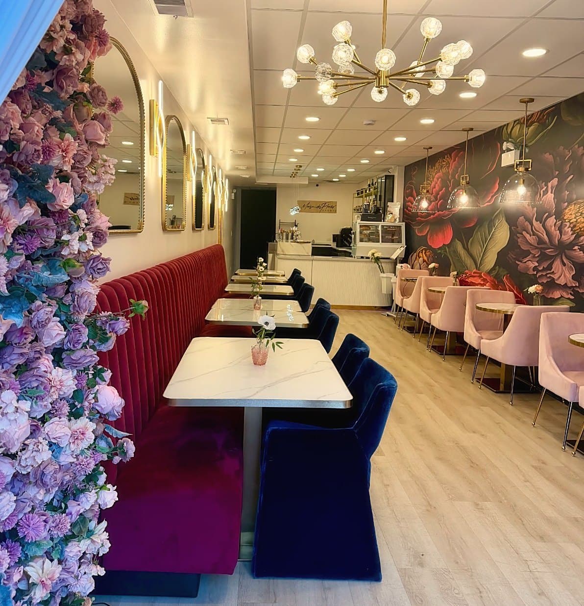 The Parlour interior with floral wall, velvet seating, and chandelier