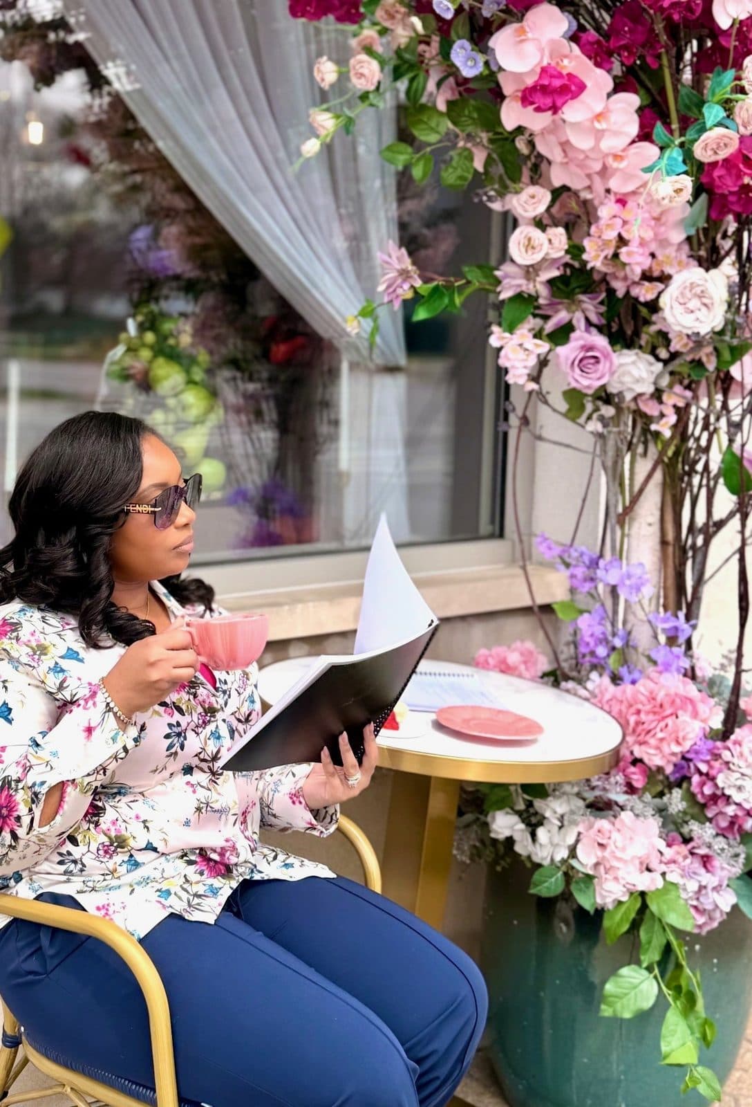 A guest enjoying tea outside The Parlour amid blooming florals