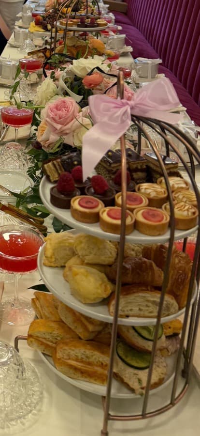 The Afternoon Tea birdcage presentation with pastries, scones, sandwiches, and fresh roses