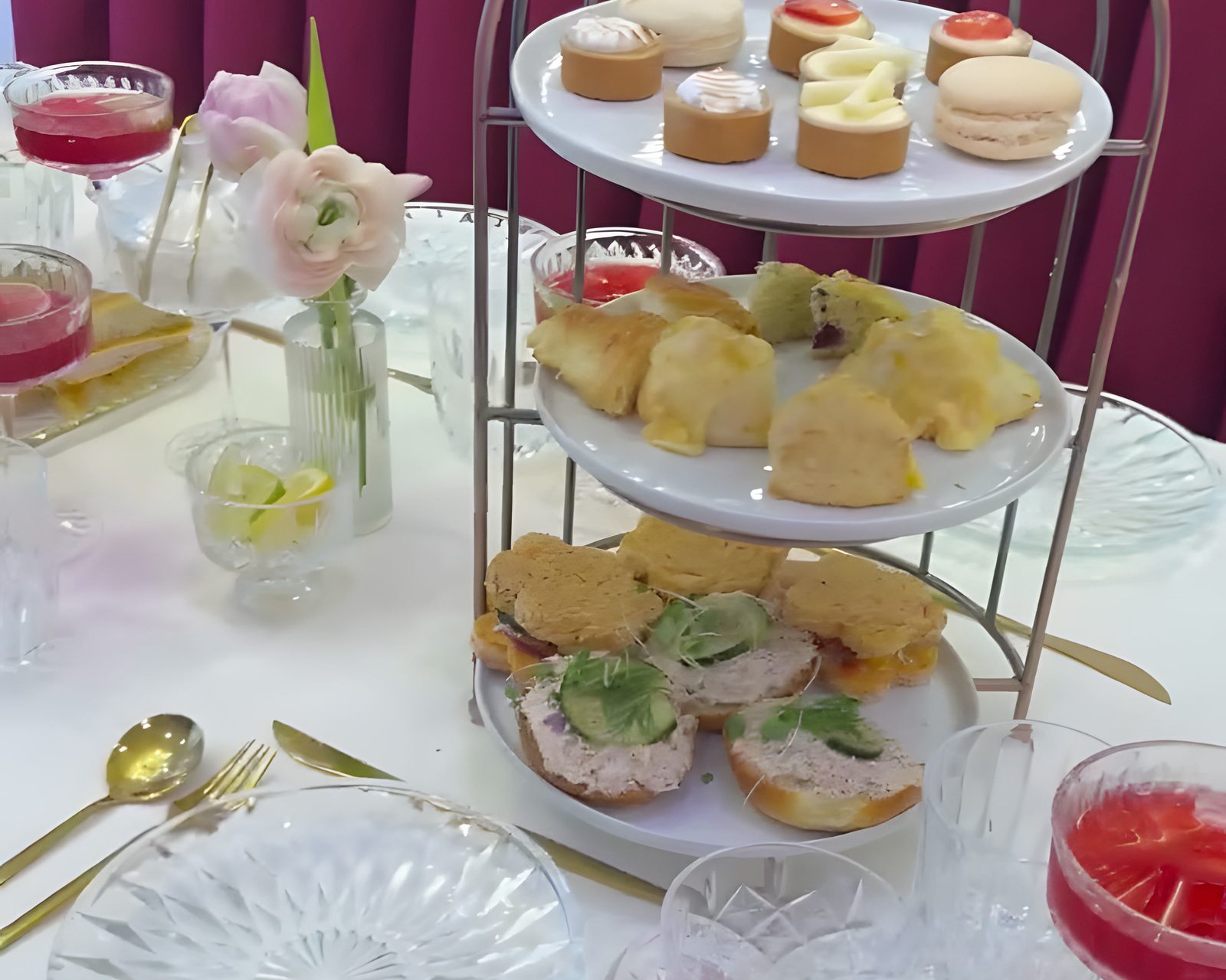 A three-tier tea service with macarons, scones, and finger sandwiches at The Parlour
